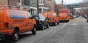 Water Damage Restoration Vans And Trucks Lined Up At Urban Job Location